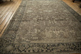 Geometric border and muted field patterns on a distressed vintage Mehrivan carpet.