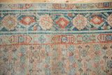 Distressed Malayer runner border with terracotta pomegranate vines, checkered floral field, foundation showing.