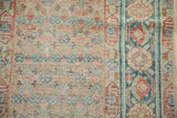 Malayer runner's distressed field and border, showing faded terracotta and dusty blue floral motifs.