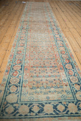 Teal and madder red pomegranate vine motif on distressed Malayer rug border.