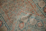 Distressed antique Malayer rug texture, camel, terracotta, and dusty teal floral motifs, foundation showing.