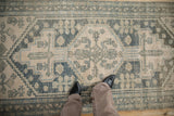 Distressed vintage Hamadan runner with stylized geometric motifs in soft teal and ivory.
