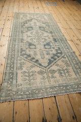 Distressed Hamadan runner's worn pile, dusty teal geometric finial and germinating plant motifs.