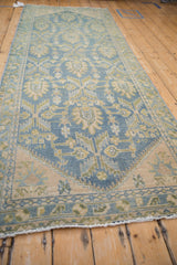 Distressed vintage Hamadan runner pile with even wear, exposed foundation, and pale blue, ivory, gold geometric motifs.