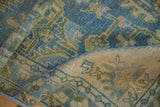 Folded Hamadan runner's texture, showing distressed dusty blue, green, and ivory leaf patterns.