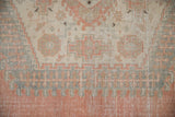 Worn texture and geometric patterns in soft cantaloupe, ivory, and slate blue on vintage Veece carpet.