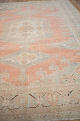 Distressed vintage Veece carpet showing faded cantaloupe, slate blue, and geometric hook patterns.