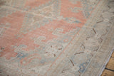 Distressed Veece carpet's geometric border with brown motifs, dusty cantaloupe field.