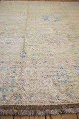 Distressed Afghani Oushak rug pile revealing foundation, pale green, blue tones, and fringe.
