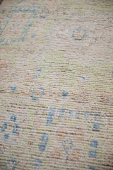 Textural detail of the distressed Afghani Oushak carpet with nuanced pale lime green and sky blue.