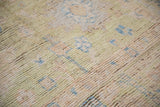Distressed Oushak pile detail, showing shearing, visible foundation, and muted pastel hues.