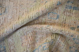 Textured pile detail of distressed Oushak rug featuring pale blue and lime green.