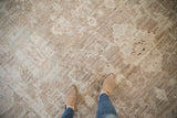 Distressed Afghani Oushak carpet with soft, sheared ivory-beige pile, subtle palmettes, and feet.