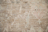 High-sheen, textured wool pile of distressed Afghani Oushak rug in neutral tones.