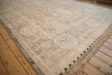 Distressed Afghani Oushak carpet displaying nuanced floral palmettes, high-sheen wool pile, and braided selvage.