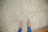 Distressed Afghani Moroccan rug pile showing ivory, powder blue, and platinum trellis pattern.