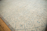 Distressed ivory and powder blue Afghani Moroccan design carpet, showing trellis pattern and side selvage.