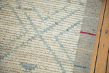 Distressed Afghani Moroccan rug close-up: ivory, powder blue diamond trellis, shearing, and red selvage.