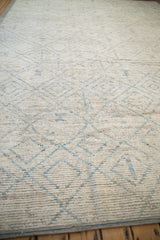 Textured pile of distressed Afghani Moroccan rug, showing ivory, powder blue trellis, and visible foundation.