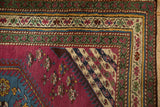 Antique Karabagh rug corner, featuring an ivory floral border, sapphire blue motif, and deep purple field.