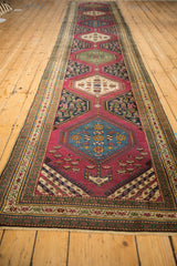 Left border, deep berry field, and ivory medallion with floral motifs on an antique Karabagh runner.