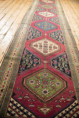 Antique Karabagh runner detail: emerald green medallion with floral bouquet and ruby pink henna motifs.