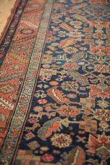 Serrated leaf border and floral Herati design on an Antique Heriz runner in navy and madder red.