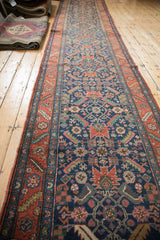 Antique Heriz rug: navy field with starburst palmettes and madder root red serrated leaf border.