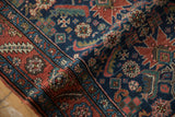 Antique Heriz runner's pile texture highlights Herati motif, starburst palmettes, and serrated leaf border.
