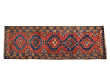 Vintage Northwest Persian runner rug with sapphire blue geometric medallions on a deep red field, 3'4