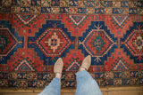 Vintage Northwest Persian runner's geometric guls and hook motifs in madder red and blue.