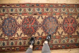 Alternating sapphire blue and brick red medallions on a sand-colored vintage Serab rug runner.