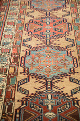 The repeating column of geometric medallions on a dense, hand-knotted vintage Serab rug runner.