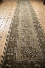 Decorative distressed Melas runner close-up, beige field with inverted quatrefoil motifs and geometric border.