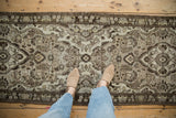 View showing the scale and distressed, low-pile texture of a vintage Persian runner rug.