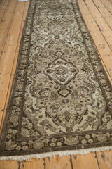 Angled view of a distressed Dargezine rug runner's floral medallion pattern in brown and silver tones.