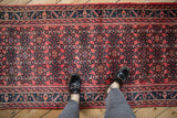 Cherry red field with dusty teal Herati motif and serrated leaf border on vintage Hamadan runner.