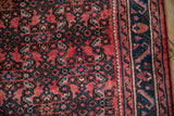 Vintage Hamadan rug detail: cherry red Herati field meets serrated leaf main border.