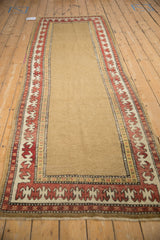 Corner of antique Caucasian runner with madder red pawn plant border and camel field.
