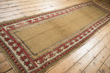 Antique Caucasian rug: deep madder red reciprocating pawn germinating plant motif, camel field.