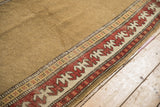 Antique Caucasian runner border shows reciprocating pawn motif, deep madder red, and natural camel field.