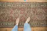 Distressed vintage Karaja runner with geometric medallions and time-softened raspberry, beige tones.