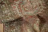 Distressed vintage Karaja runner close-up, showing geometric patterns in raspberry, silver, and beige.
