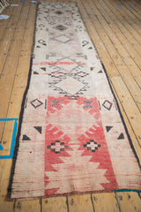 Angled view down the length of a distressed Moroccan runner showing its shifting geometric patterns.