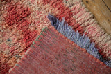 Distressed Moroccan runner reverse, showing polychromatic warps, shaggy pile, and lavender fringe.