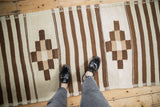 Geometric detail of vintage Moroccan runner: ivory, beige, dark copper checkered medallions, stripes.
