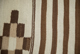 Detail of vintage Moroccan runner rug showing varied geometric patterns in ivory and dark copper.