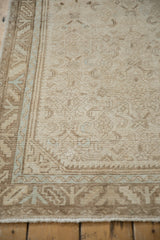 Distressed Hamadan runner corner: serrated leaf border, visible knot heads, faded blue accents.