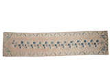 Vintage distressed Oushak rug runner with geometric floral patterns in blue and ivory on a soft mauve field.