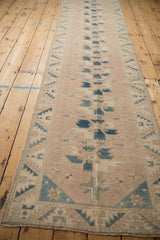 Angled perspective showing the decorative geometric pattern along a vintage Oushak rug runner.